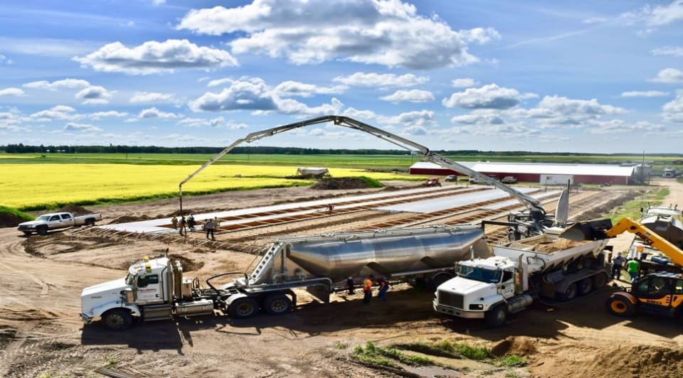 A truck is parked next to a tanker trailer.