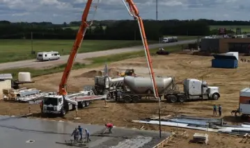 A cement truck is being worked on by workers.